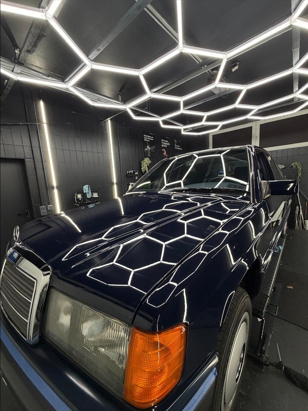Klassischer Mercedes 190 in Schwarz mit Hexagon-Reflexion auf der Motorhaube