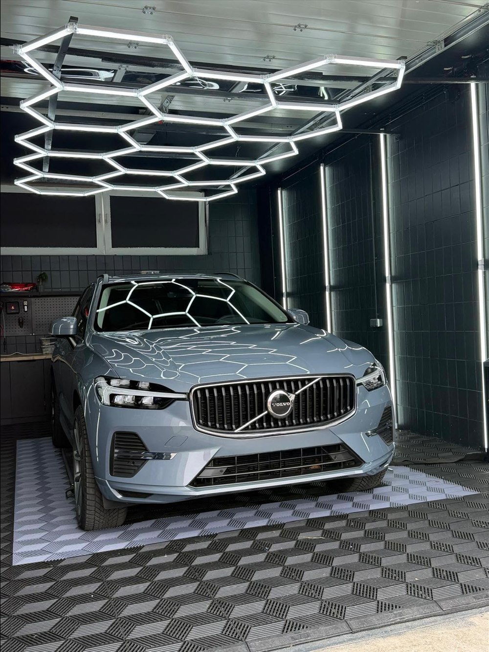Volvo XC60 in Grau unter dem Hexagon-Licht im Detailing-Studio